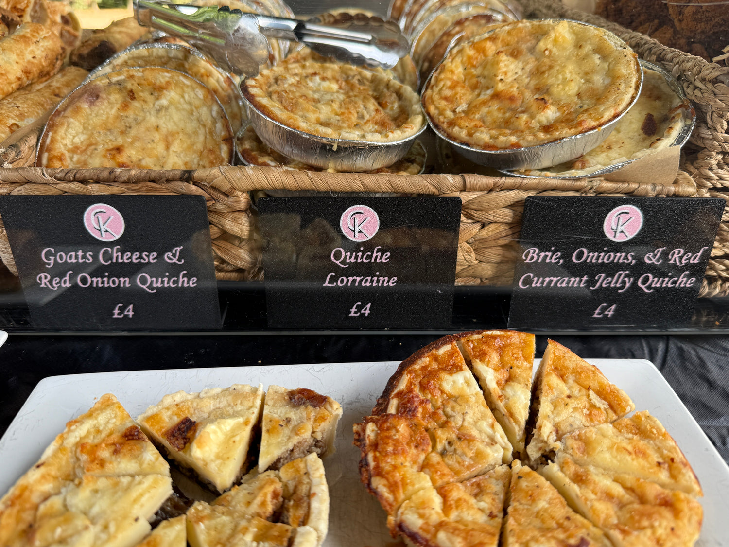 Custom product signage for a small business selling food items like sausage rolls, scotch eggs, and quiche